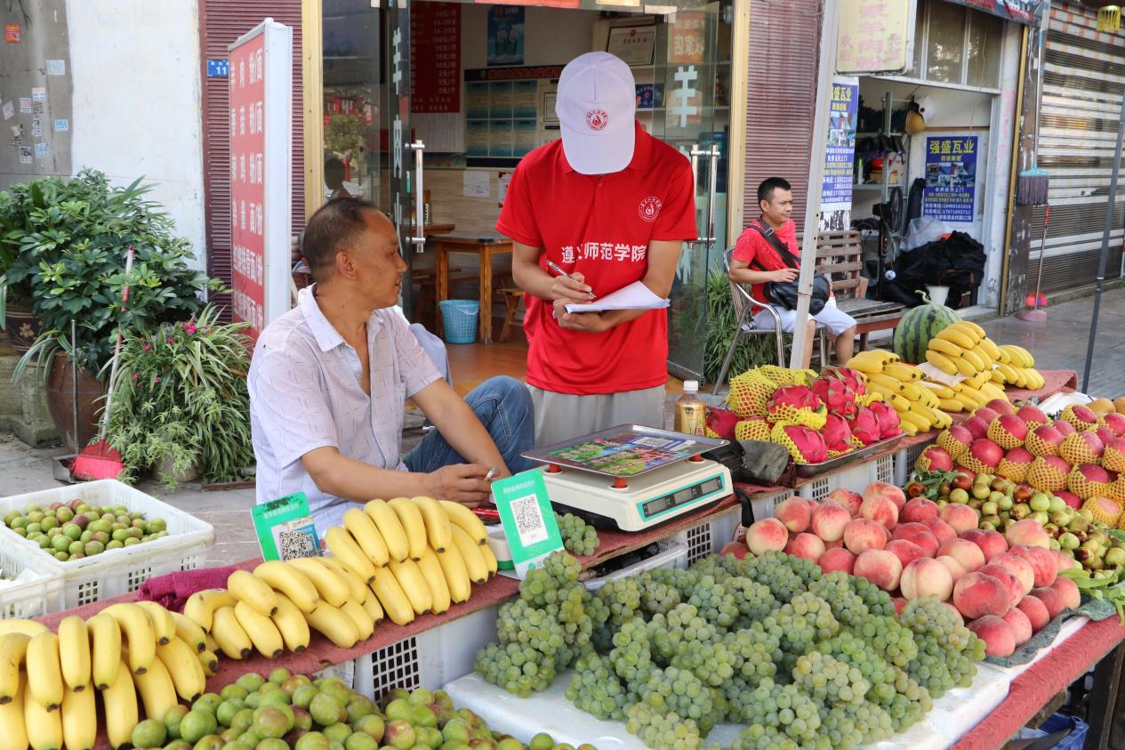图为实践队员在鱼泉街道进行问卷调研和一对一宣讲。张冰鑫 供图