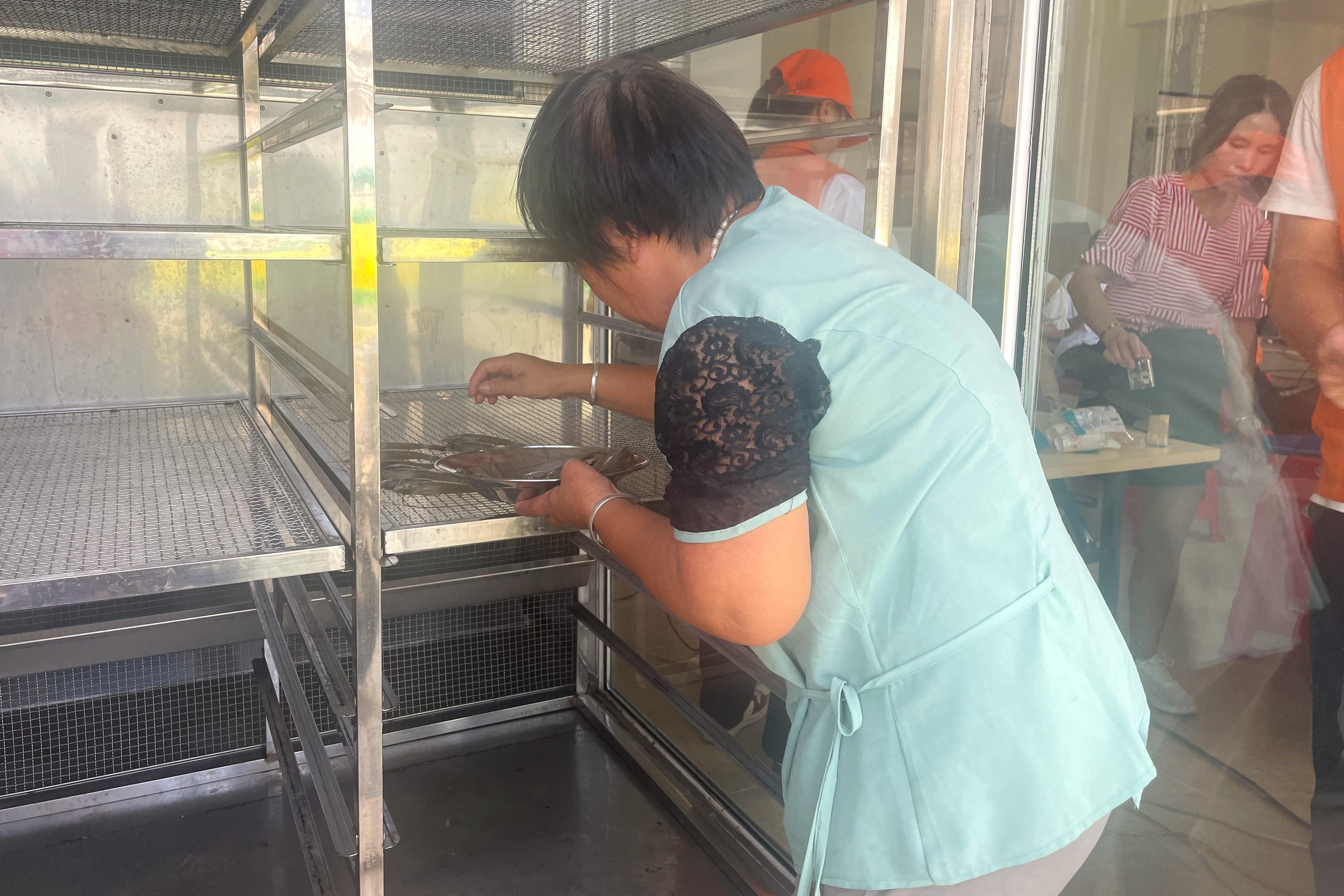 05图为渔农把鲜虾放入试验机中加工。阳江职业技术学院 胡昊钊提供