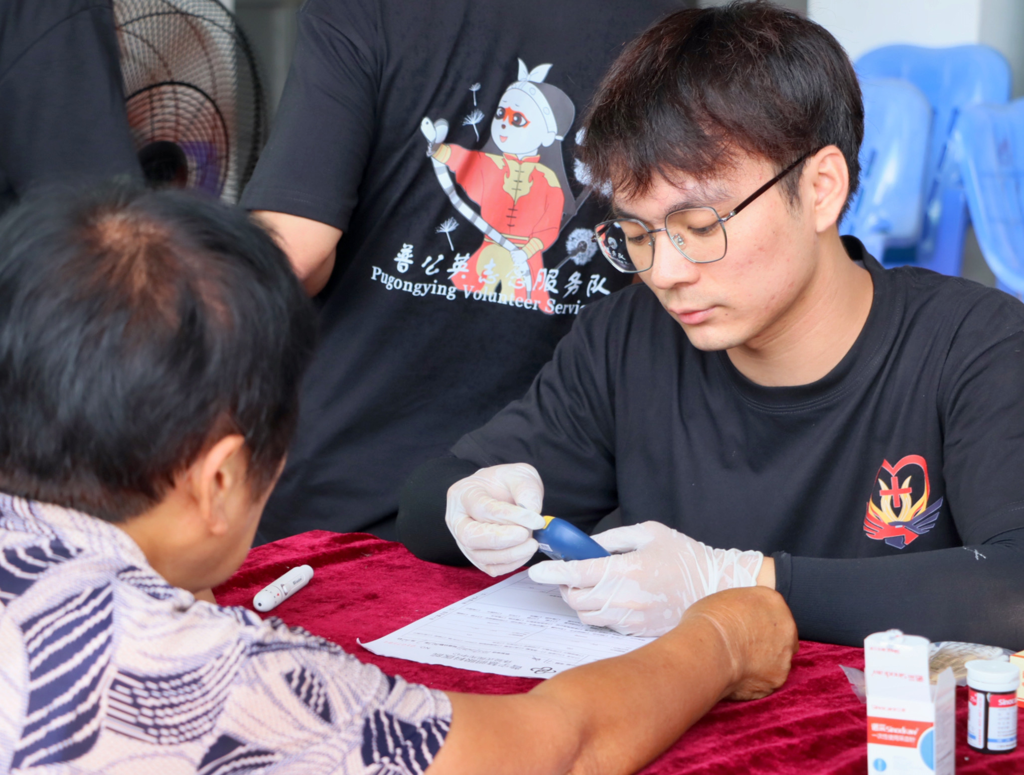 图为服务队队员为村民测量血糖。广东医科大学梁茵提供