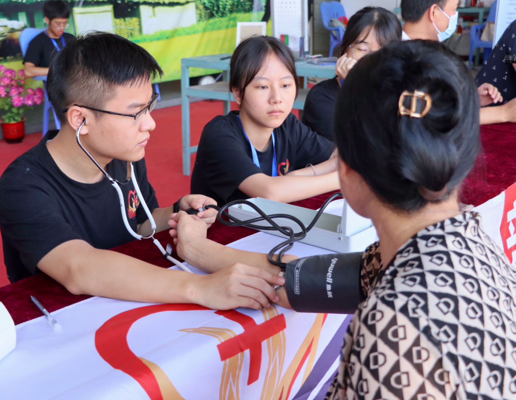 图为服务队队员为村民测量血压。广东医科大学梁茵提供