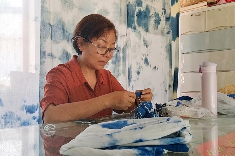图为李梅老师缝制蓝染作品。