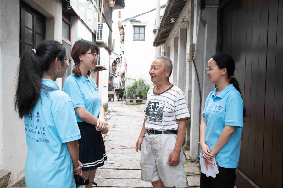 图为实践团成员们与古镇居民交流 河海大学 高畅提供