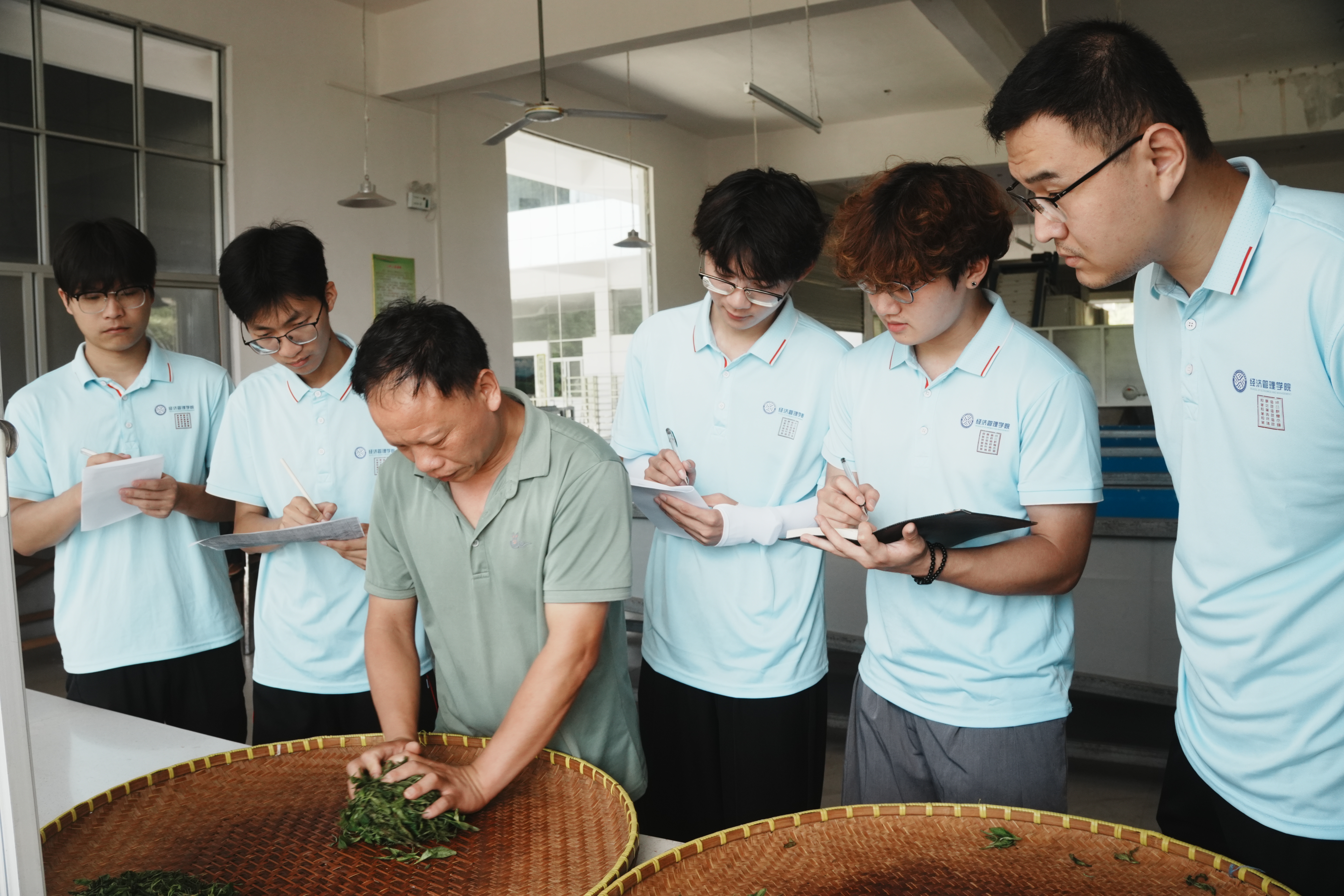 圖為首位興國工匠為實踐隊員們示范揉捻茶葉。周文濤 攝