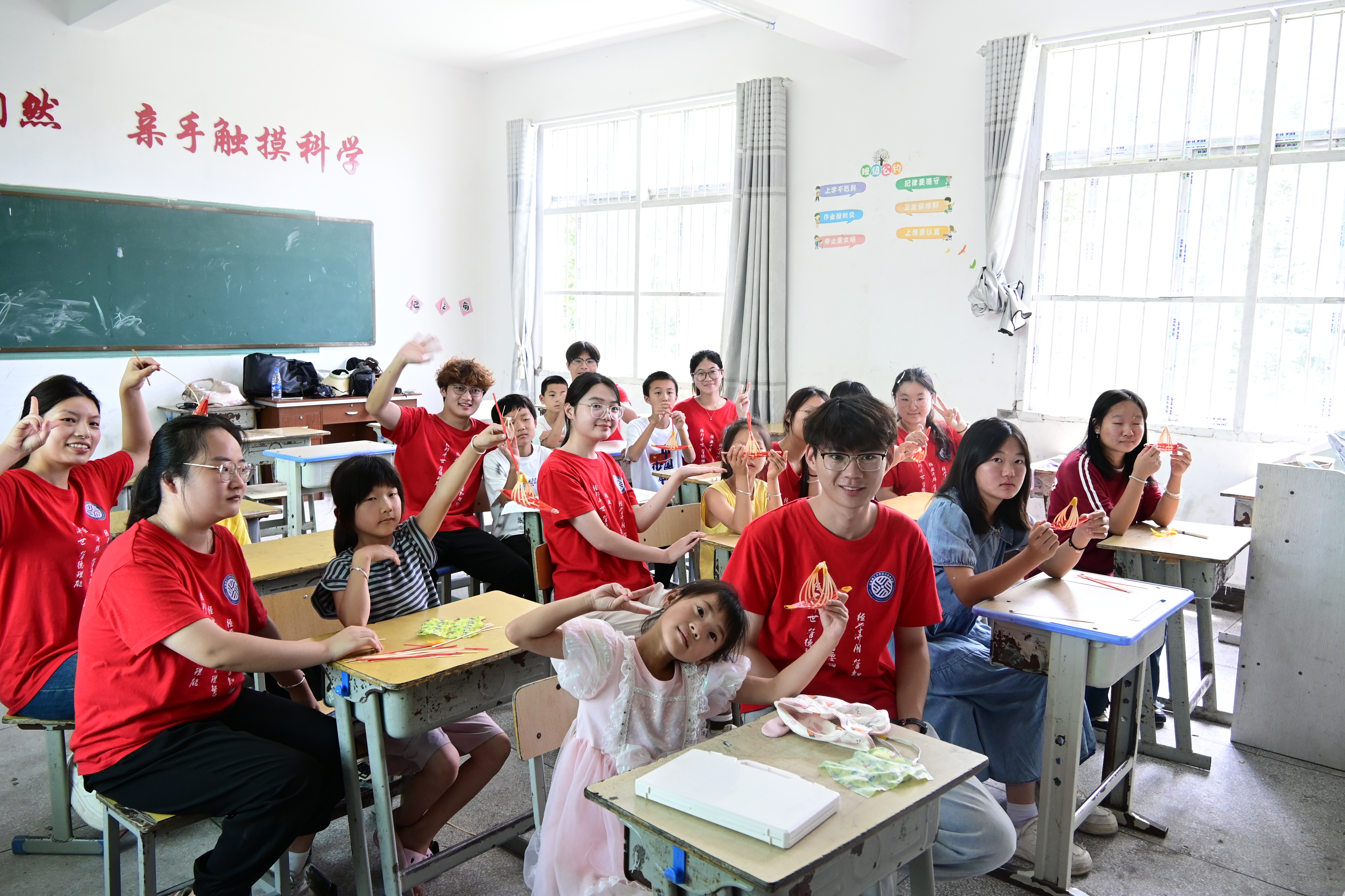 圖為實踐隊員和當地留守兒童采用本地竹廠的剩余原料共同制作紅船。謝晶晶 沈亦飛攝