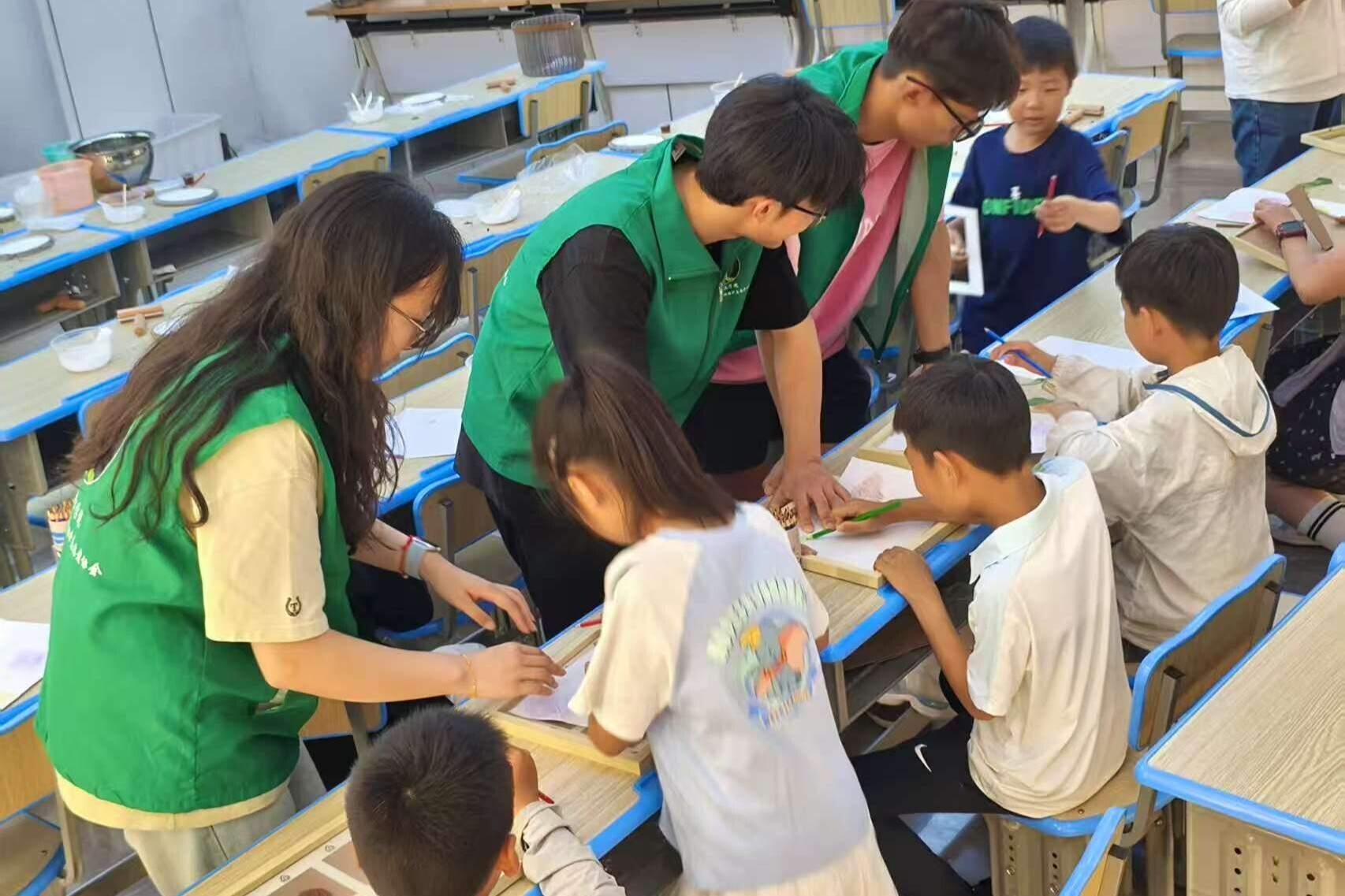 图为自然纹理拓印环节，实践团成员协助小朋友固定植物与调试颜料，科普树叶等自然纹理的知识。马宇政 供图