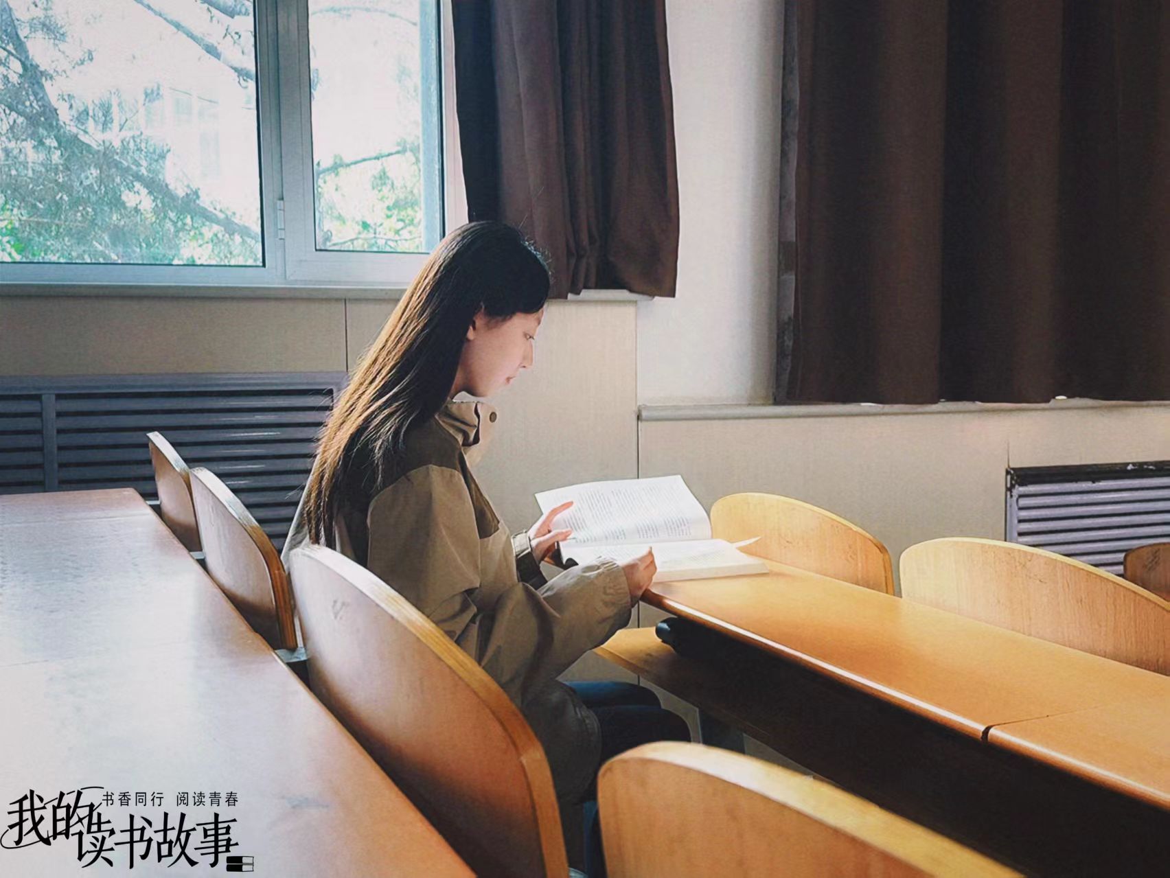 在空荡的教室里，她于木质桌椅间与书本低语，窗外的绿意与室内的沉静相映，每一次目光停留都是对知识的虔诚探寻。